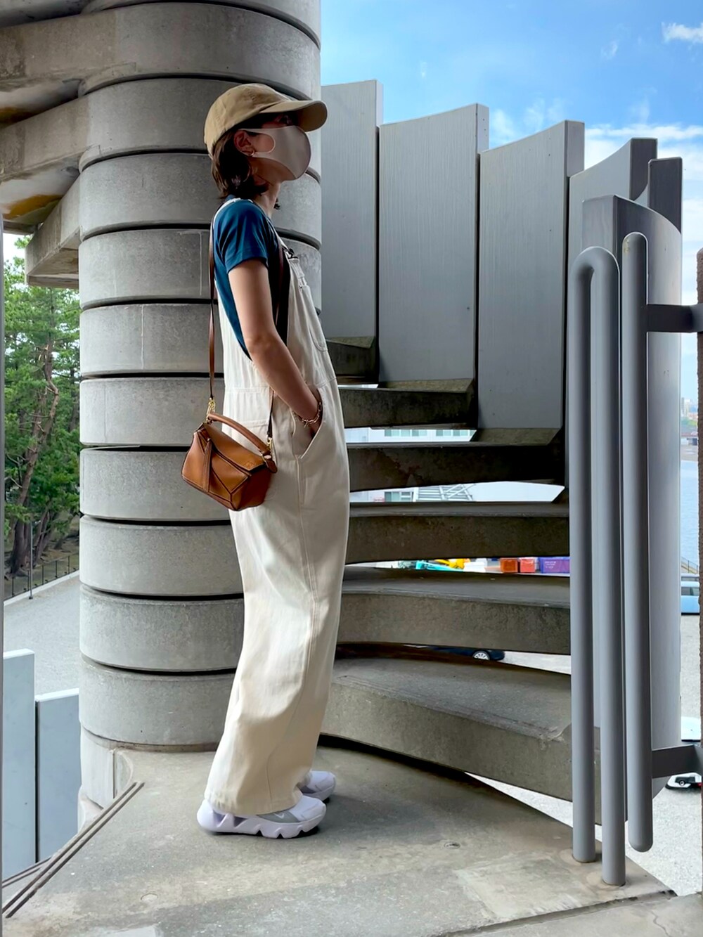 ホワイト系のサロペット/オーバーオール、ブルー系のTシャツ/カットソー、ホワイト系のスニーカーを着用したレディースの秋コーディネートの2枚目の写真