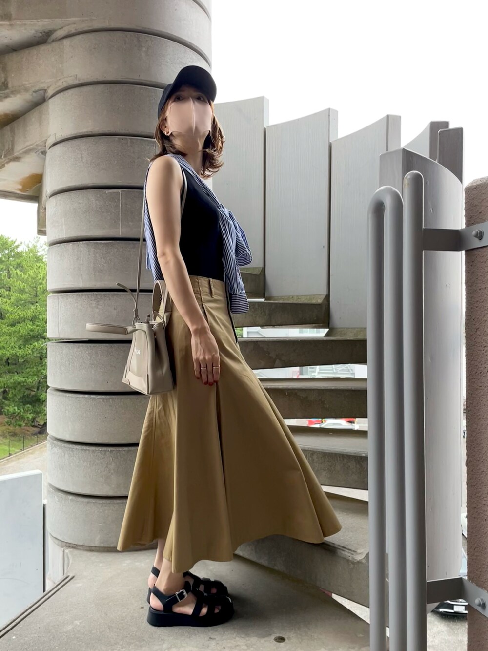 ブルー系のシャツ/ブラウス、ベージュ系のショルダーバッグ、ベージュ系のスカートを着用したレディースの秋コーディネートの2枚目の写真