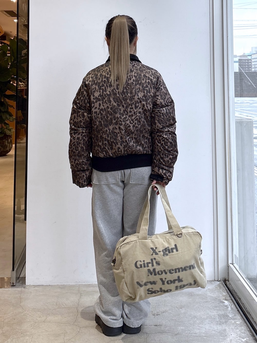 ベージュ系のナイロンジャケット、グレー系のスウェットパンツ、ベージュ系のトートバッグを着用したレディースの秋コーディネートの2枚目の写真