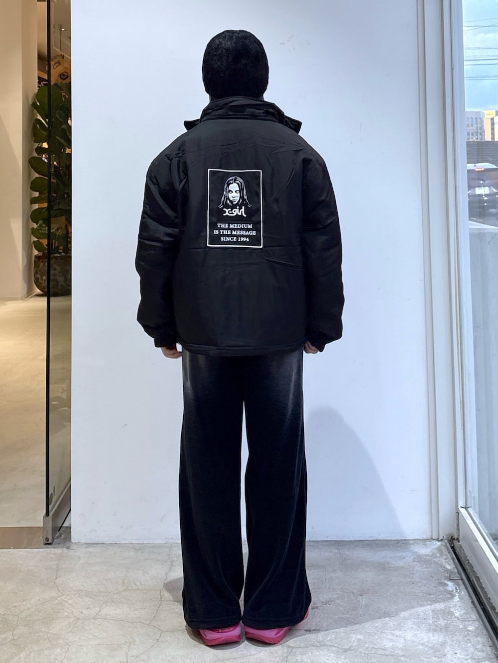 ピンク系のスウェット、ブラック系のナイロンジャケット、ブラック系のその他パンツを着用したレディースの秋コーディネートの2枚目の写真