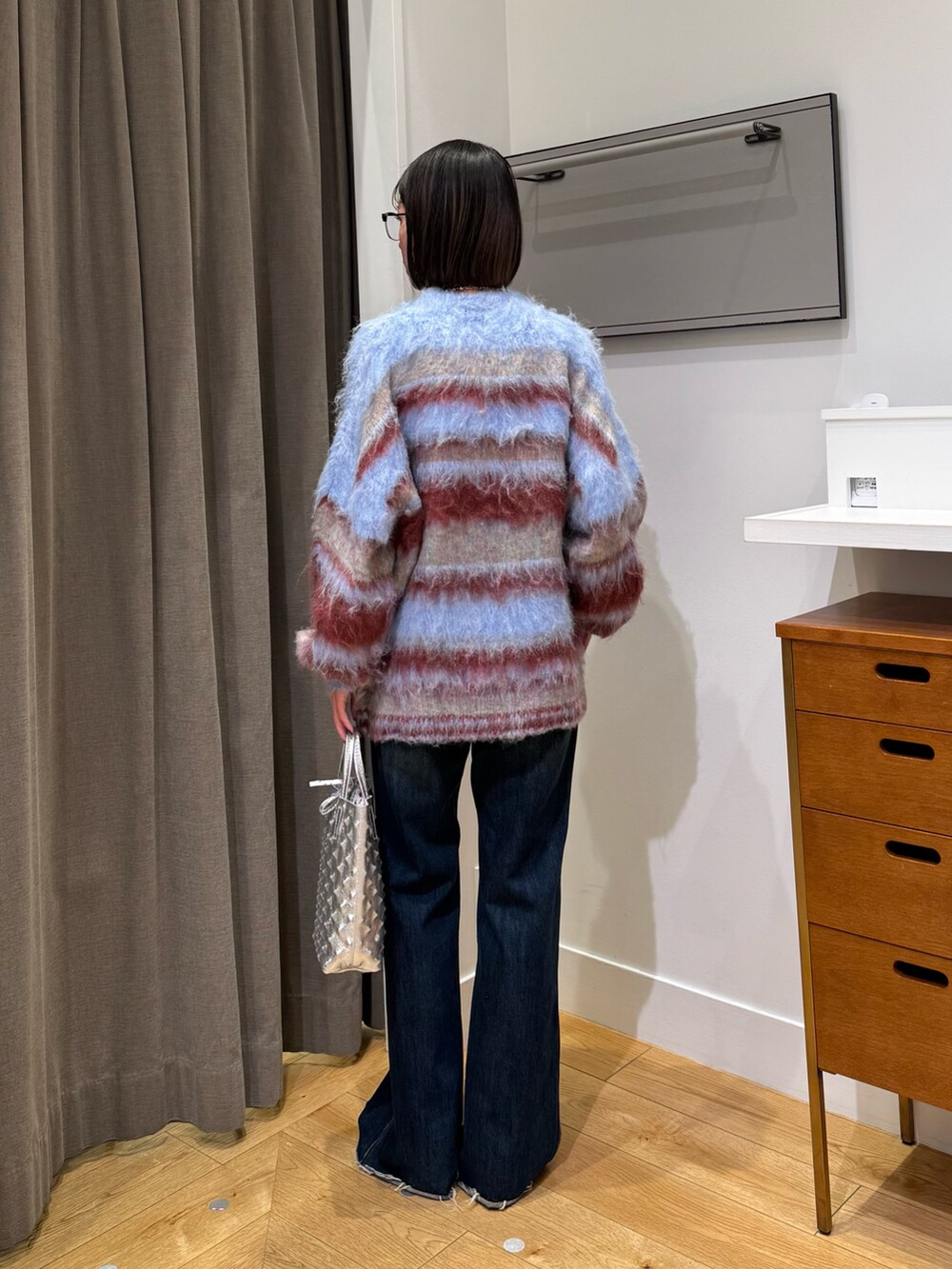 ブルー系のニット/セーター、ブルー系のデニムパンツ、ブラック系のブーツを着用したレディースの冬コーディネートの3枚目の写真