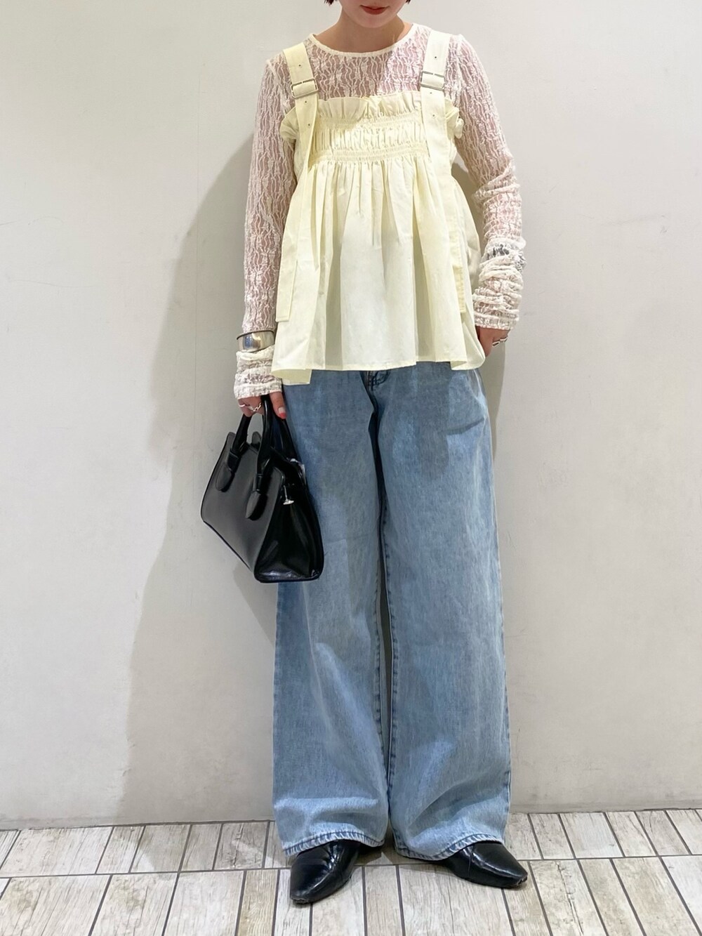 ブラック系のボストンバッグ、ブルー系のデニムパンツ、ホワイト系のその他トップスを着用したレディースの春コーディネートの2枚目の写真