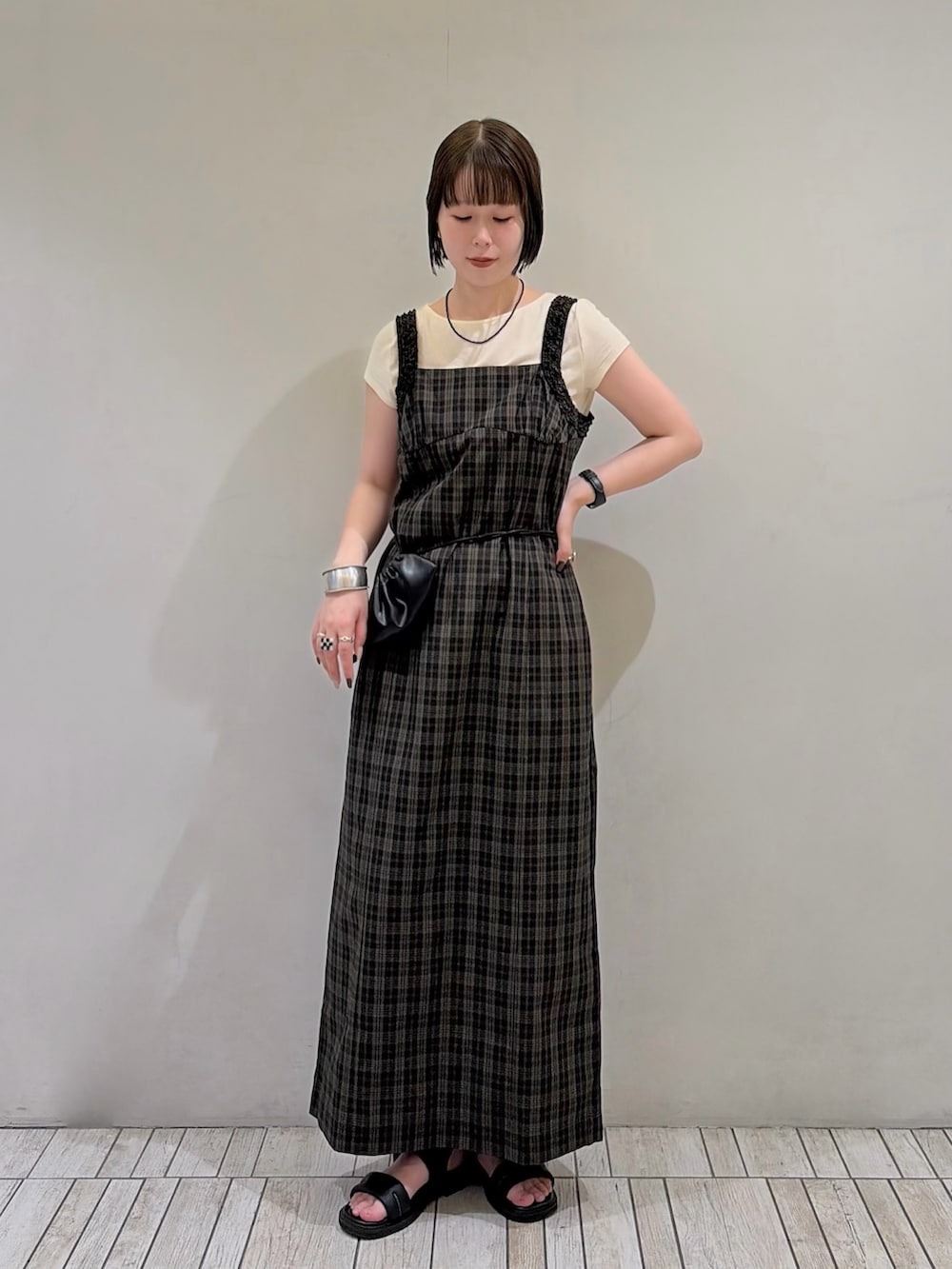 ブラック系のワンピース、イエロー系のTシャツ/カットソー、ブラック系のポーチを着用したレディースの夏コーディネートの2枚目の写真