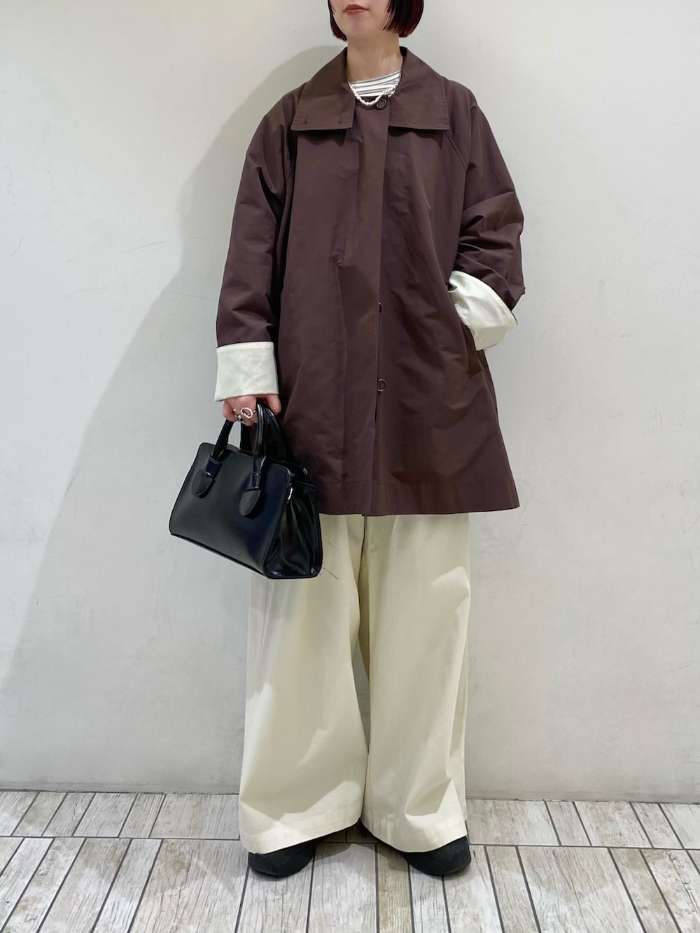 ブラック系のボストンバッグ、ホワイト系のTシャツ/カットソー、ブラウン系のその他アウターを着用したレディースの春コーディネートの3枚目の写真