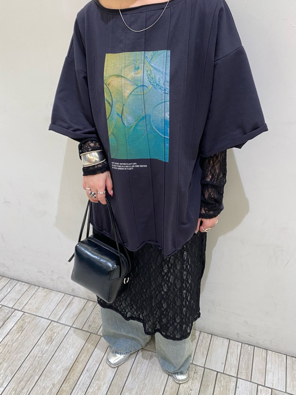 ブルー系のデニムパンツ、ブルー系のTシャツ/カットソー、ブラック系のショルダーバッグを着用したレディースの春コーディネートの4枚目の写真