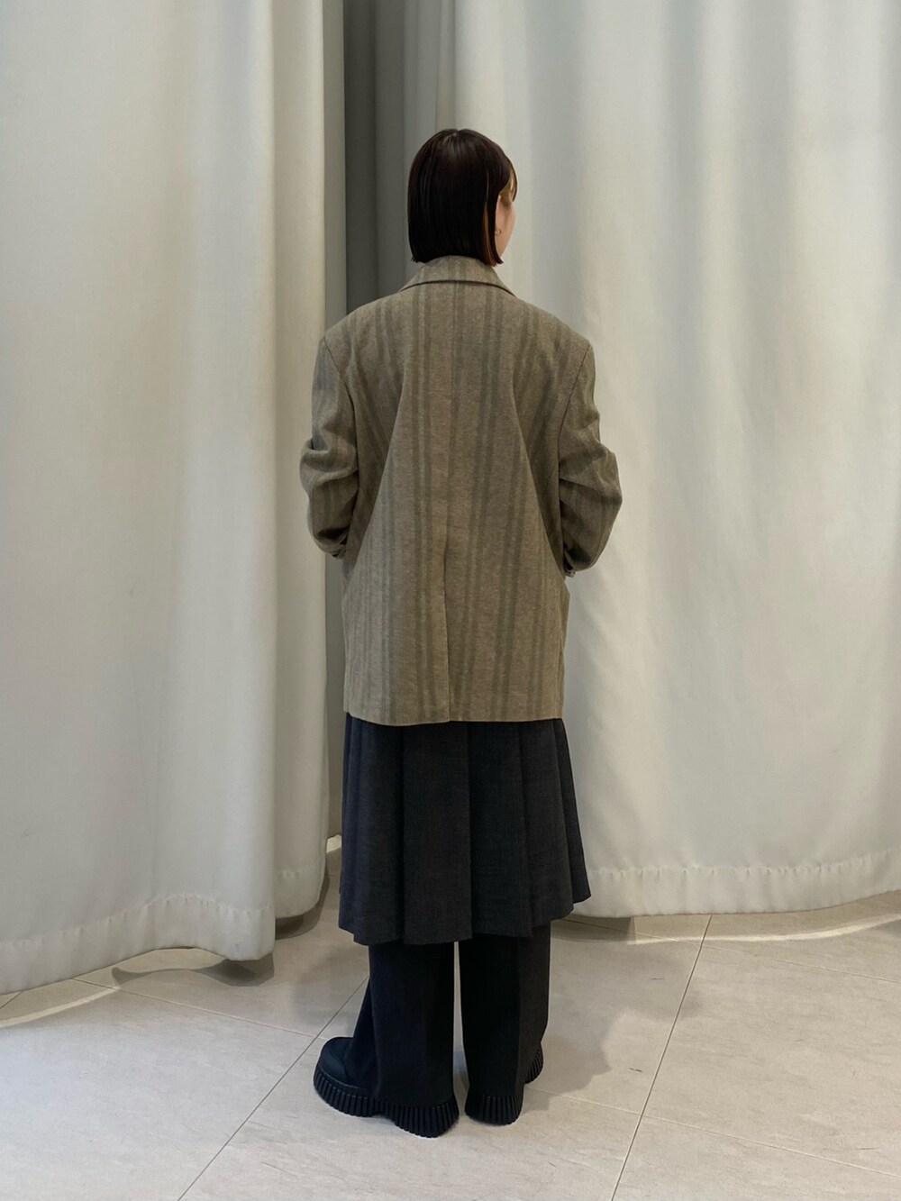 グリーン系のその他アウター、グレー系のTシャツ/カットソー、グリーン系のスカートを着用したレディースの秋コーディネートの4枚目の写真