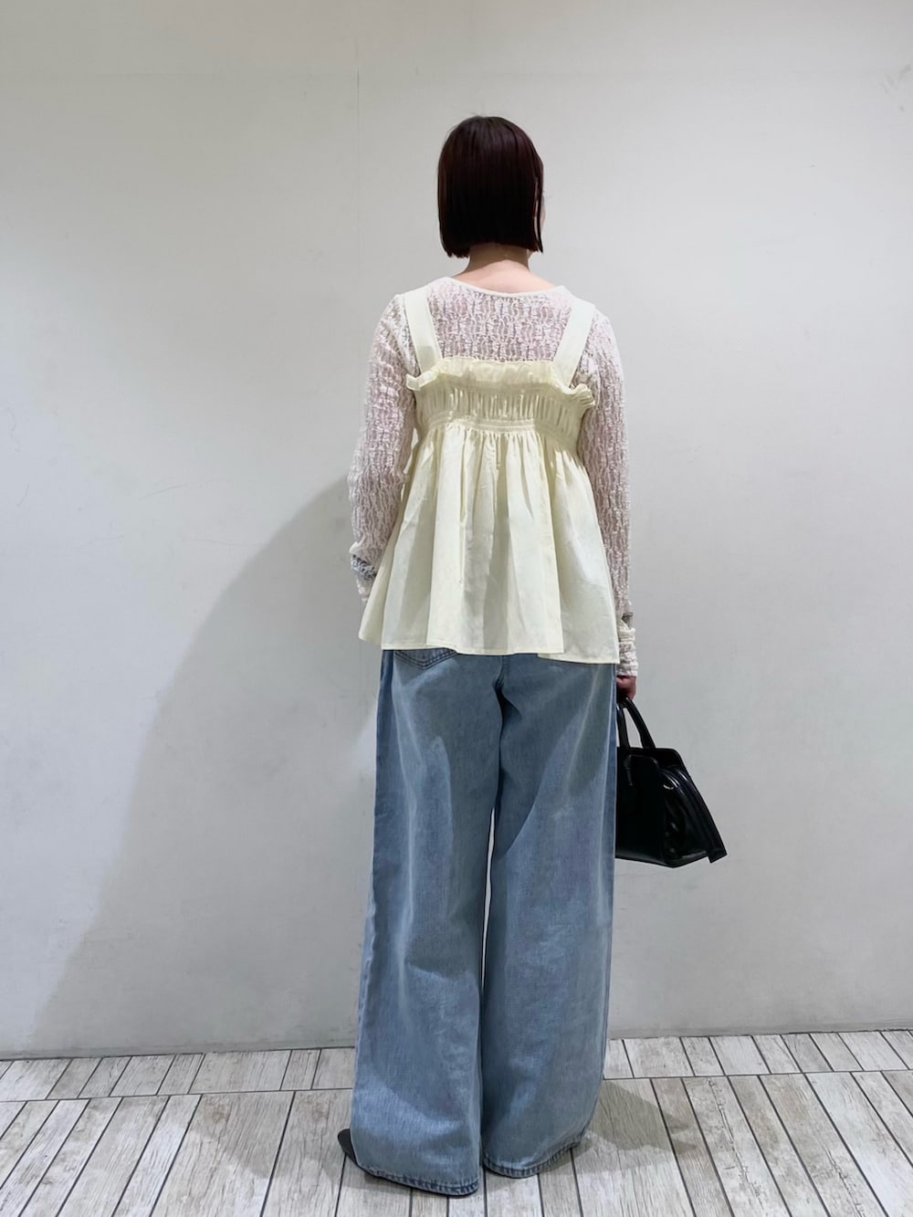 ブラック系のボストンバッグ、ブルー系のデニムパンツ、ホワイト系のその他トップスを着用したレディースの春コーディネートの3枚目の写真