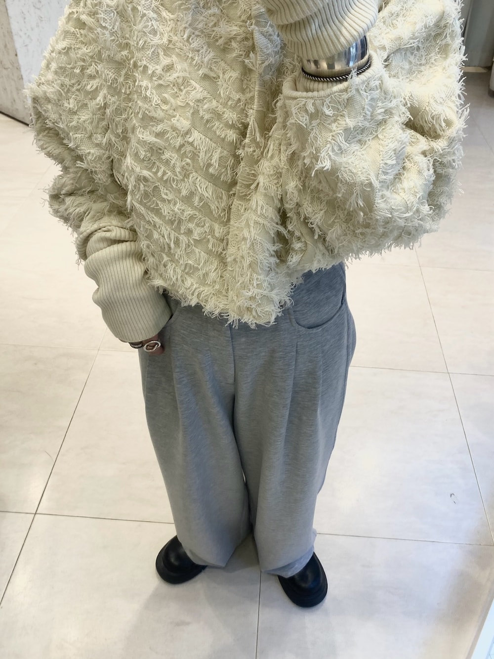 ホワイト系のカーディガン/ボレロ、ブラック系のショルダーバッグ、グレー系のその他パンツを着用したレディースの冬コーディネートの4枚目の写真