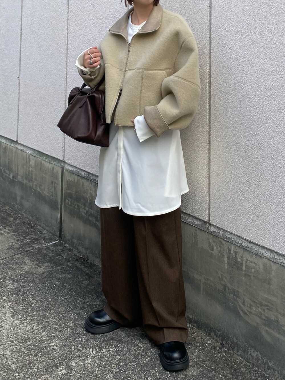 ベージュ系のその他アウター、ブラウン系のボストンバッグ、ホワイト系のワンピースを着用したレディースの秋コーディネートの2枚目の写真