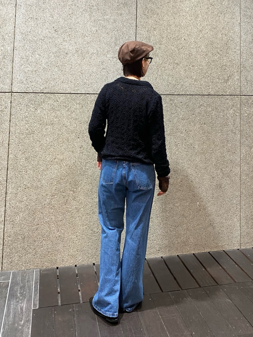 ブラック系のニット/セーター、ブラウン系のTシャツ/カットソー、ブルー系のデニムパンツを着用したレディースの冬コーディネートの3枚目の写真