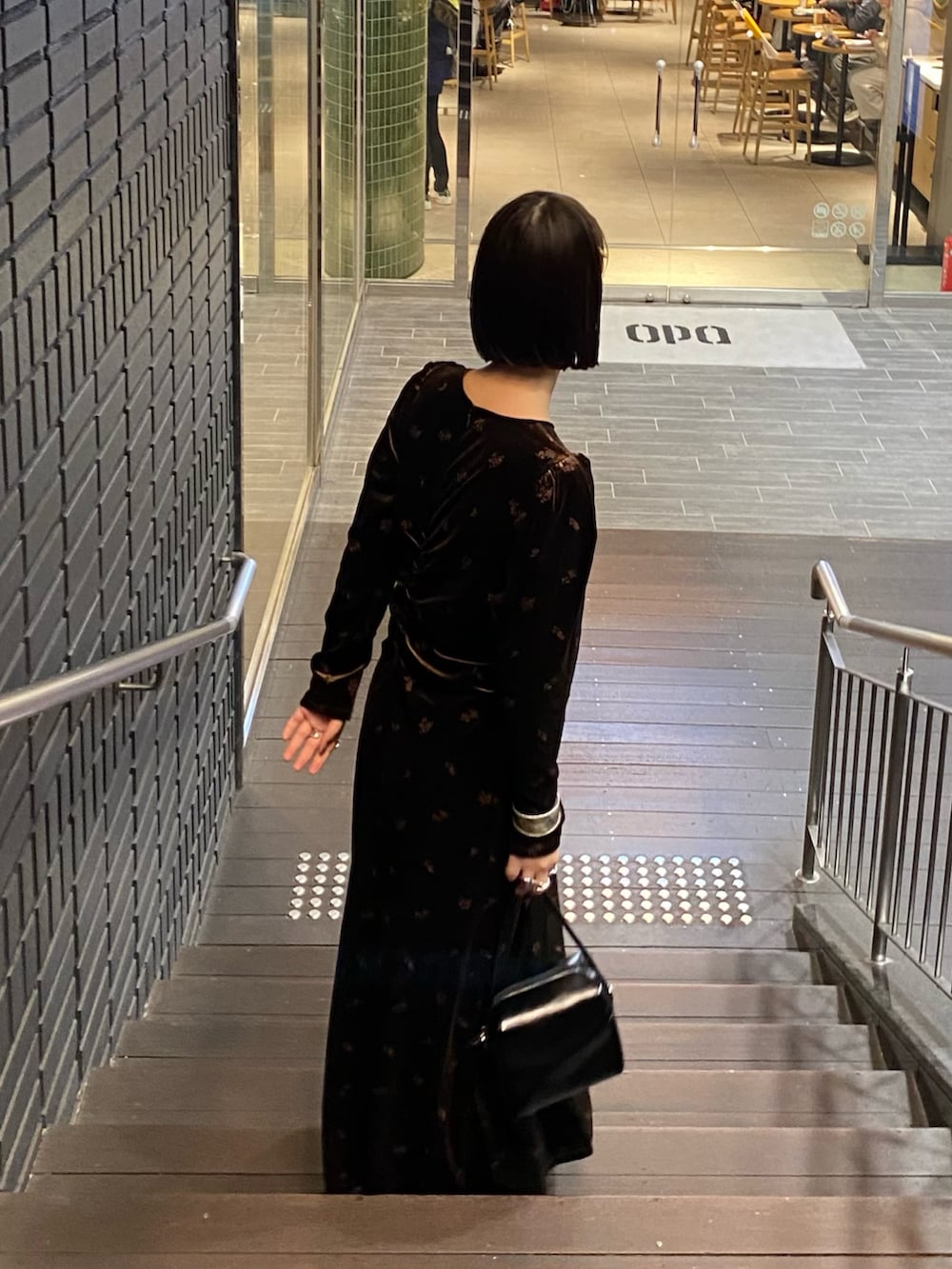 ブラウン系のワンピース、ブラック系のショルダーバッグ、ブラック系のブーツを着用したレディースの冬コーディネートの4枚目の写真