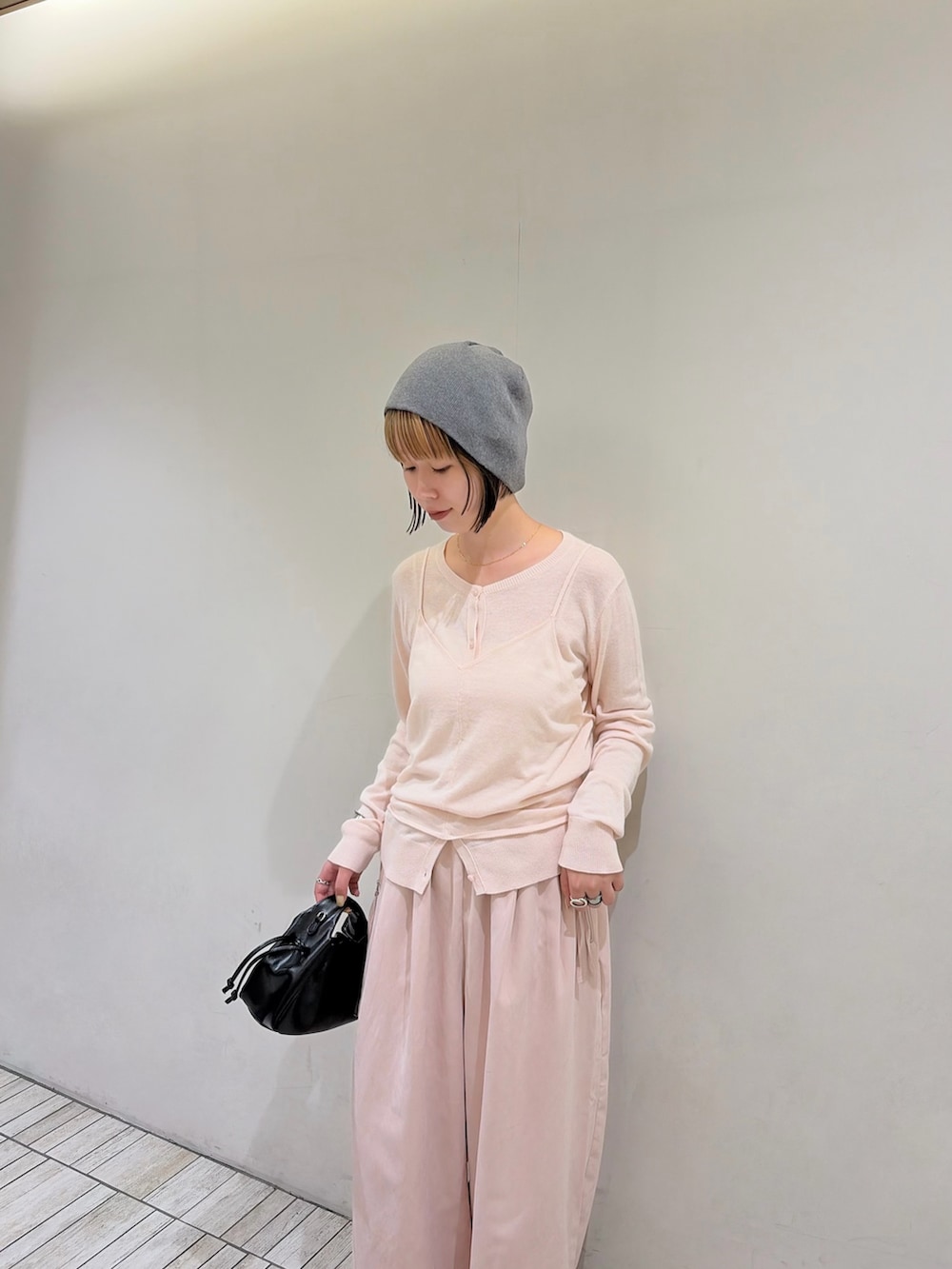 ピンク系のカーディガン/ボレロ、ピンク系のその他パンツ、ブラック系のハンドバッグを着用したレディースの秋コーディネートの3枚目の写真