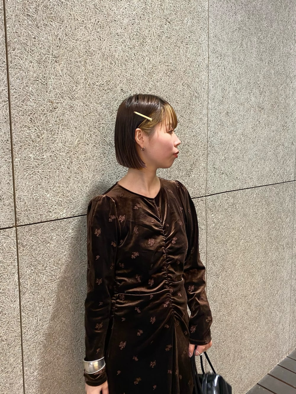 ブラウン系のワンピース、ブラック系のショルダーバッグ、ブラック系のブーツを着用したレディースの冬コーディネートの7枚目の写真