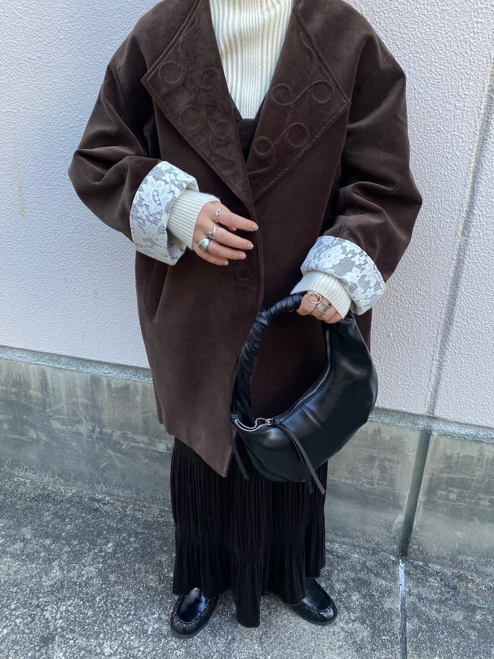 ブラック系のハンドバッグ、ブラウン系のワンピース、ブラック系のその他シューズを着用したレディースの冬コーディネートの3枚目の写真