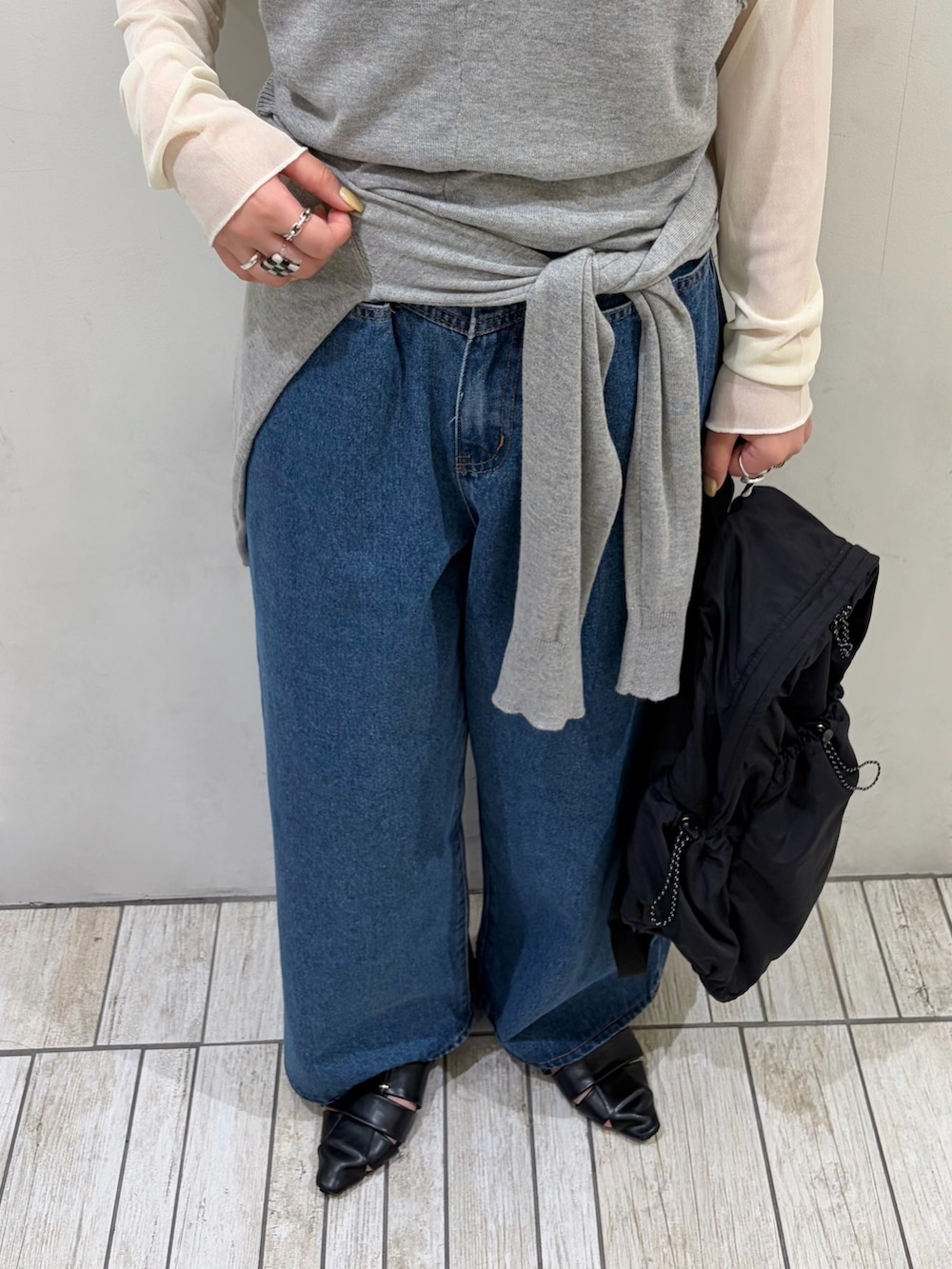 グレー系のカーディガン/ボレロ、ホワイト系のTシャツ/カットソー、ブルー系のデニムパンツを着用したレディースの秋コーディネートの2枚目の写真