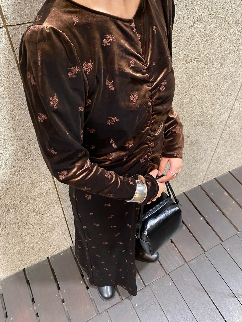 ブラウン系のワンピース、ブラック系のショルダーバッグ、ブラック系のブーツを着用したレディースの冬コーディネートの3枚目の写真