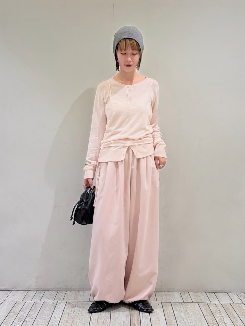 ピンク系のカーディガン/ボレロ、ピンク系のその他パンツ、ブラック系のハンドバッグを着用したレディースの秋コーディネートの2枚目の写真