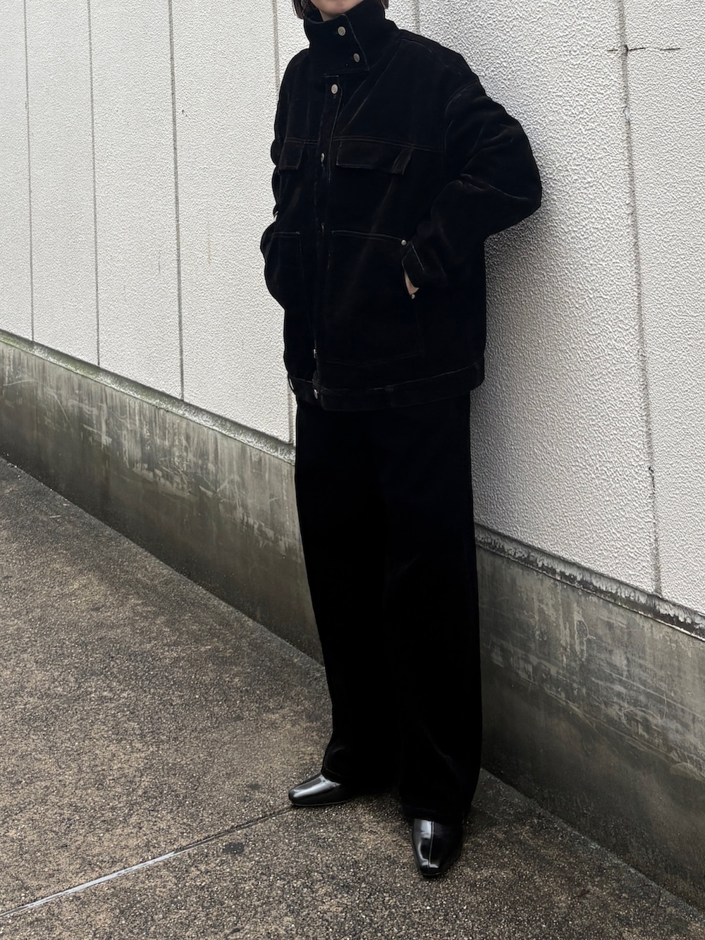 ブラック系のブルゾン、ブラック系のデニムパンツ、ブラック系のパンプスを着用したレディースの冬コーディネートの2枚目の写真