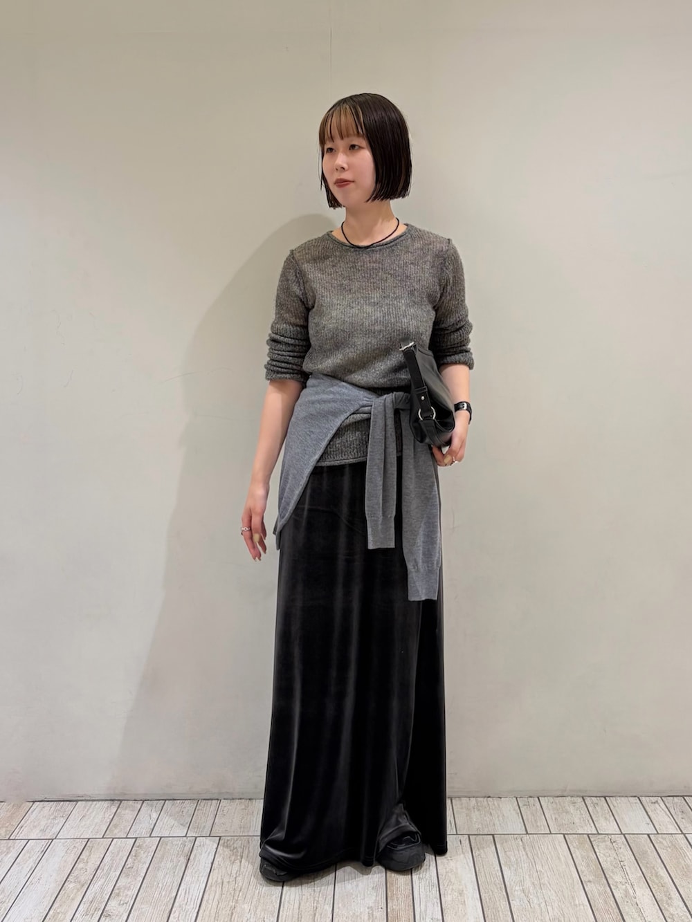 グレー系のニット/セーター、グレー系のカーディガン/ボレロ、グレー系のスカートを着用したレディースの秋コーディネートの2枚目の写真
