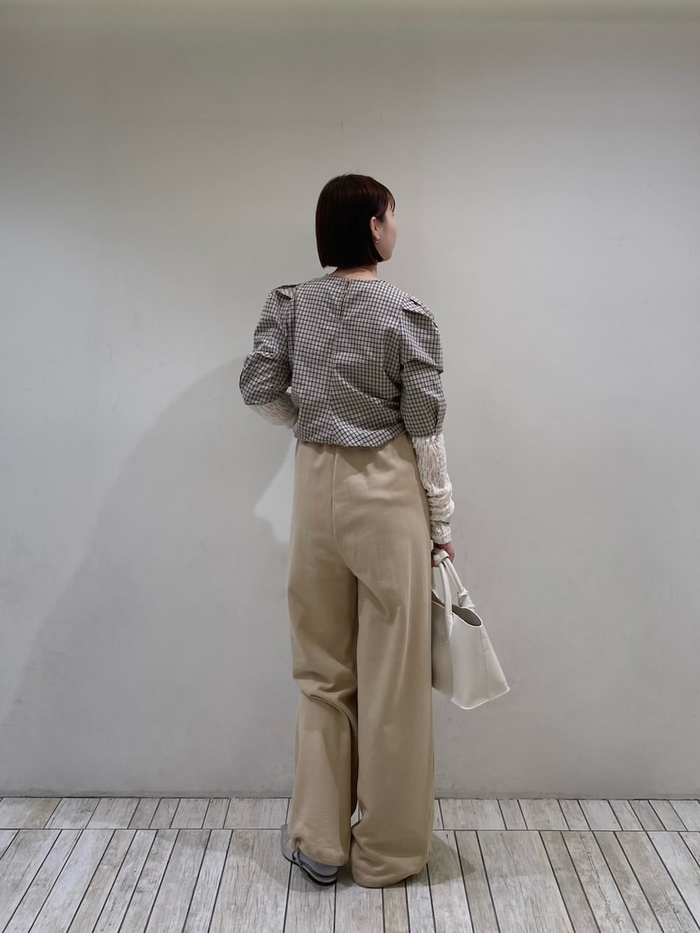 ベージュ系のシャツ/ブラウス、ベージュ系のその他パンツ、ホワイト系のハンドバッグを着用したレディースの春コーディネートの3枚目の写真