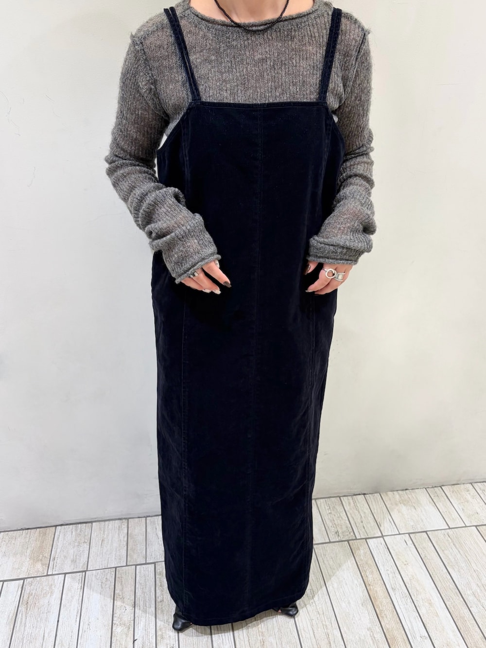 ブラック系のワンピース、グレー系のニット/セーター、ブラック系のネックレスを着用したレディースの秋コーディネートの2枚目の写真