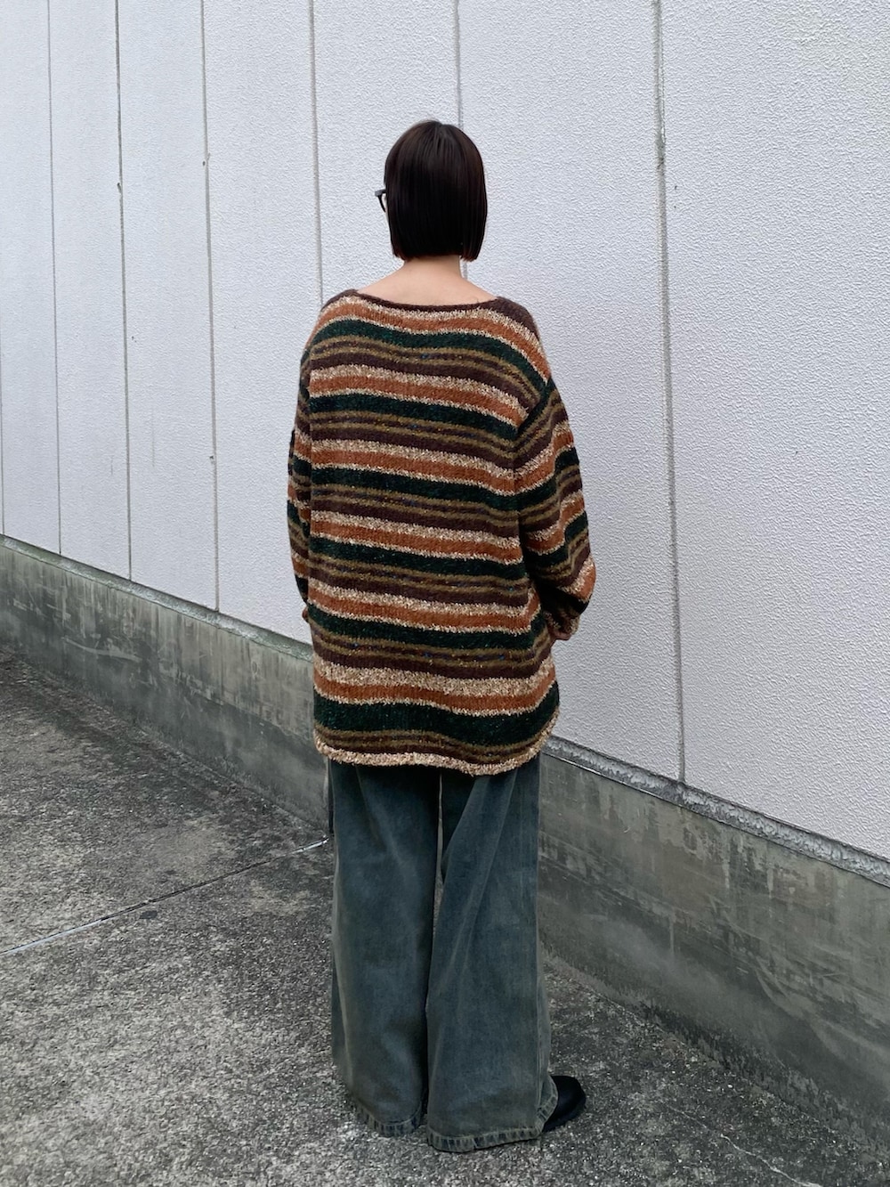 ブラウン系のニット/セーター、ブルー系のデニムパンツ、ブラック系のブーツを着用したレディースの冬コーディネートの3枚目の写真