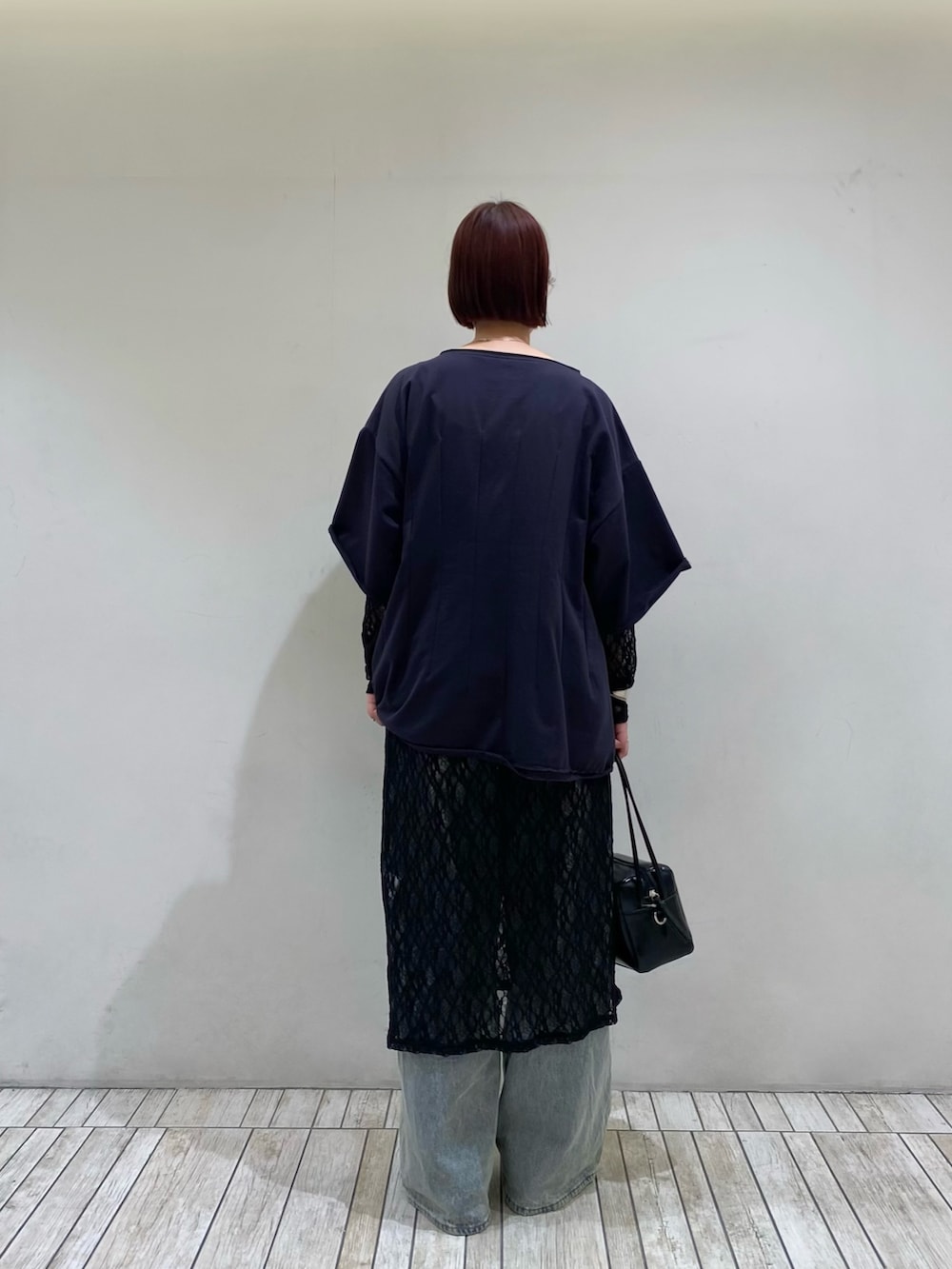 ブルー系のデニムパンツ、ブルー系のTシャツ/カットソー、ブラック系のショルダーバッグを着用したレディースの春コーディネートの3枚目の写真