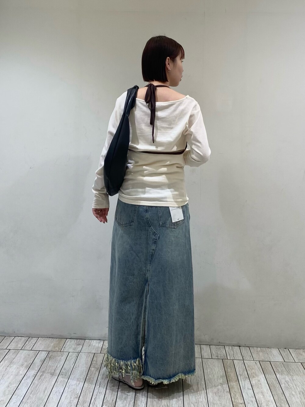 ホワイト系のTシャツ/カットソー、ブルー系のスカート、ブラック系のショルダーバッグを着用したレディースの春コーディネートの4枚目の写真