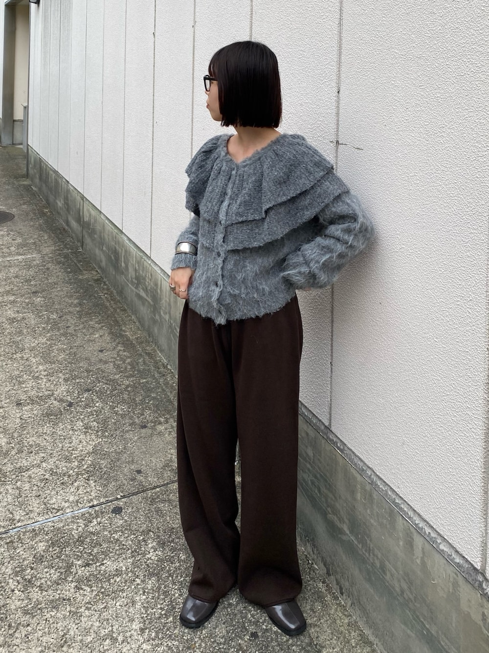 グレー系のニット/セーター、ブラウン系のその他パンツ、グレー系のその他シューズを着用したレディースの秋コーディネートの2枚目の写真