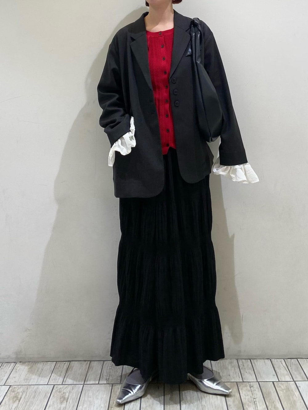 グレー系のその他アウター、レッド系のニット/セーター、ブラック系のセットアップを着用したレディースの春コーディネートの2枚目の写真