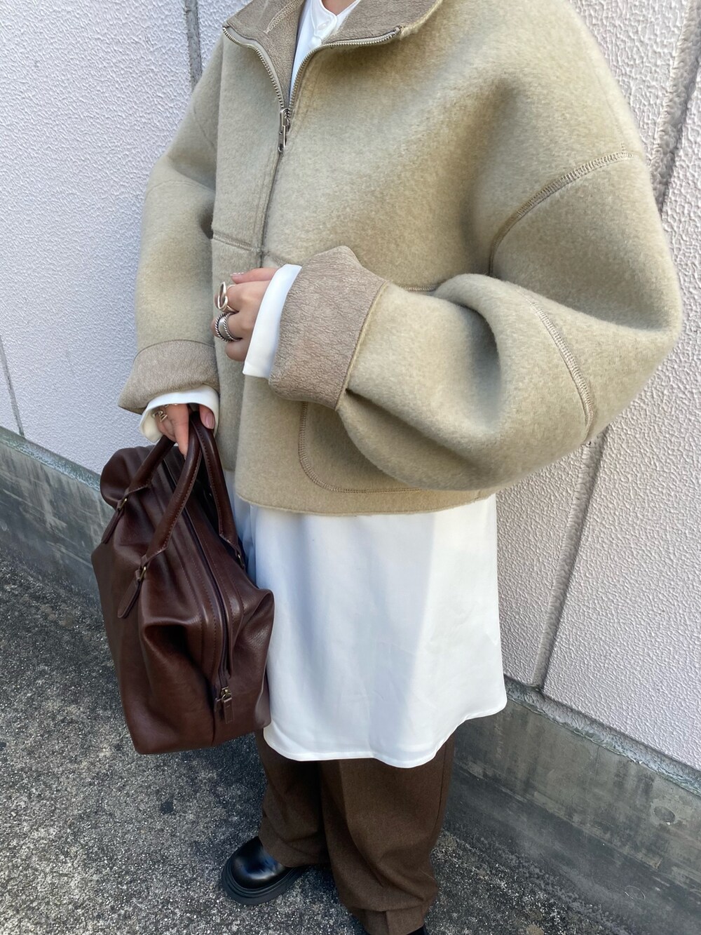 ベージュ系のその他アウター、ブラウン系のボストンバッグ、ホワイト系のワンピースを着用したレディースの秋コーディネートの4枚目の写真