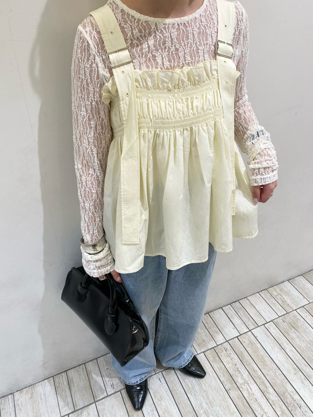 ブラック系のボストンバッグ、ブルー系のデニムパンツ、ホワイト系のその他トップスを着用したレディースの春コーディネートの4枚目の写真