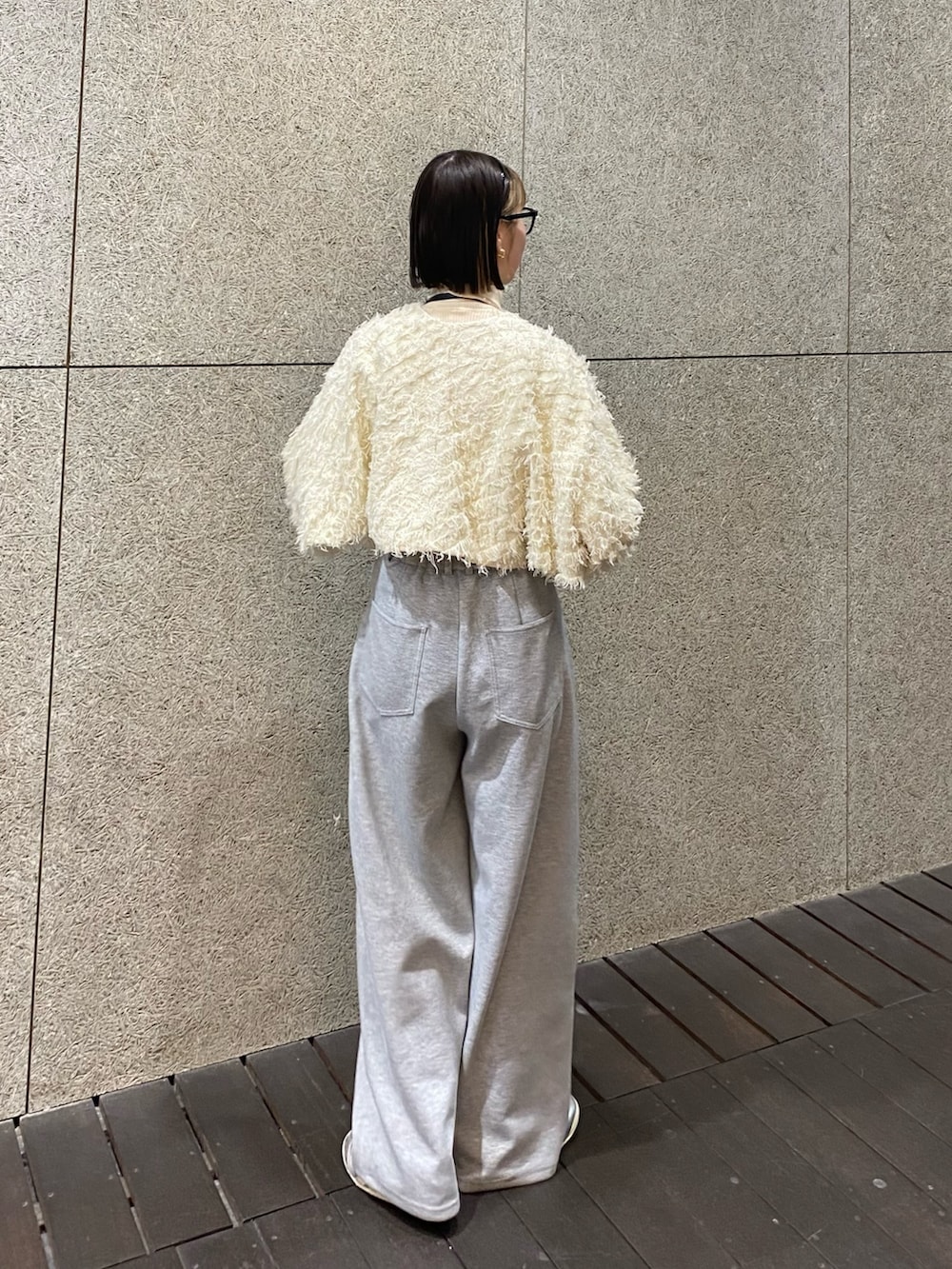 ホワイト系のカーディガン/ボレロ、ブラック系のショルダーバッグ、グレー系のその他パンツを着用したレディースの冬コーディネートの2枚目の写真