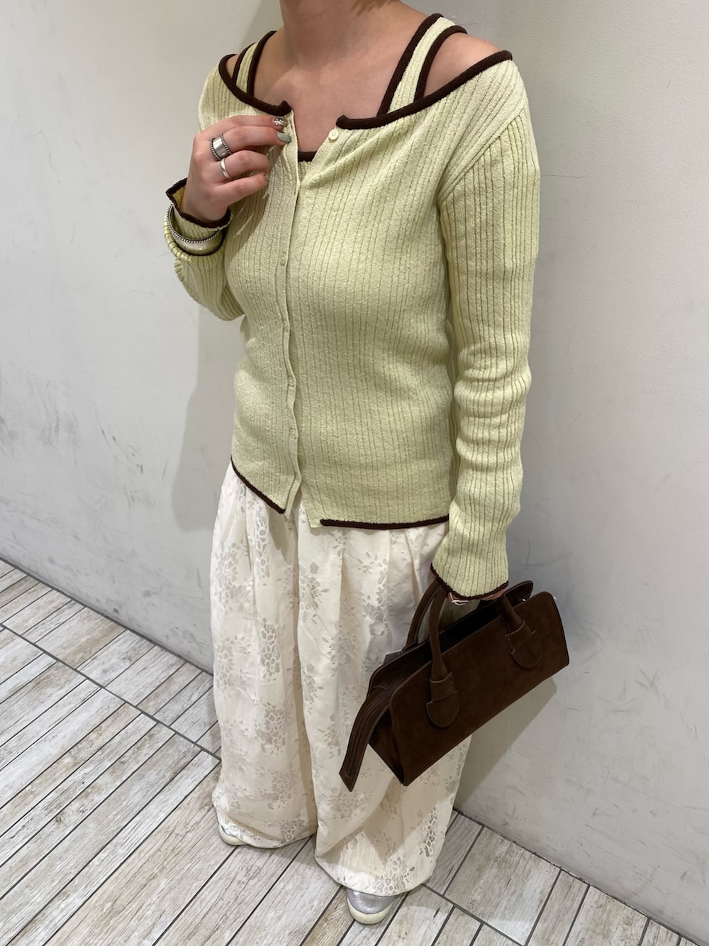 ホワイト系のその他パンツ、グリーン系のニット/セーター、ブラウン系のボストンバッグを着用したレディースの春コーディネートの3枚目の写真