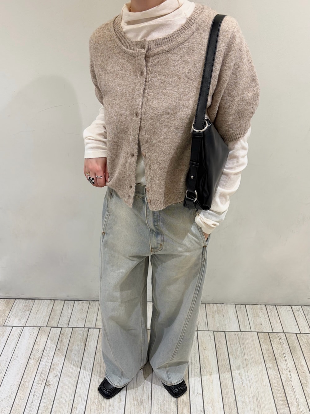 ベージュ系のカーディガン/ボレロ、ブルー系のデニムパンツ、ブラック系のショルダーバッグを着用したレディースの秋コーディネートの3枚目の写真
