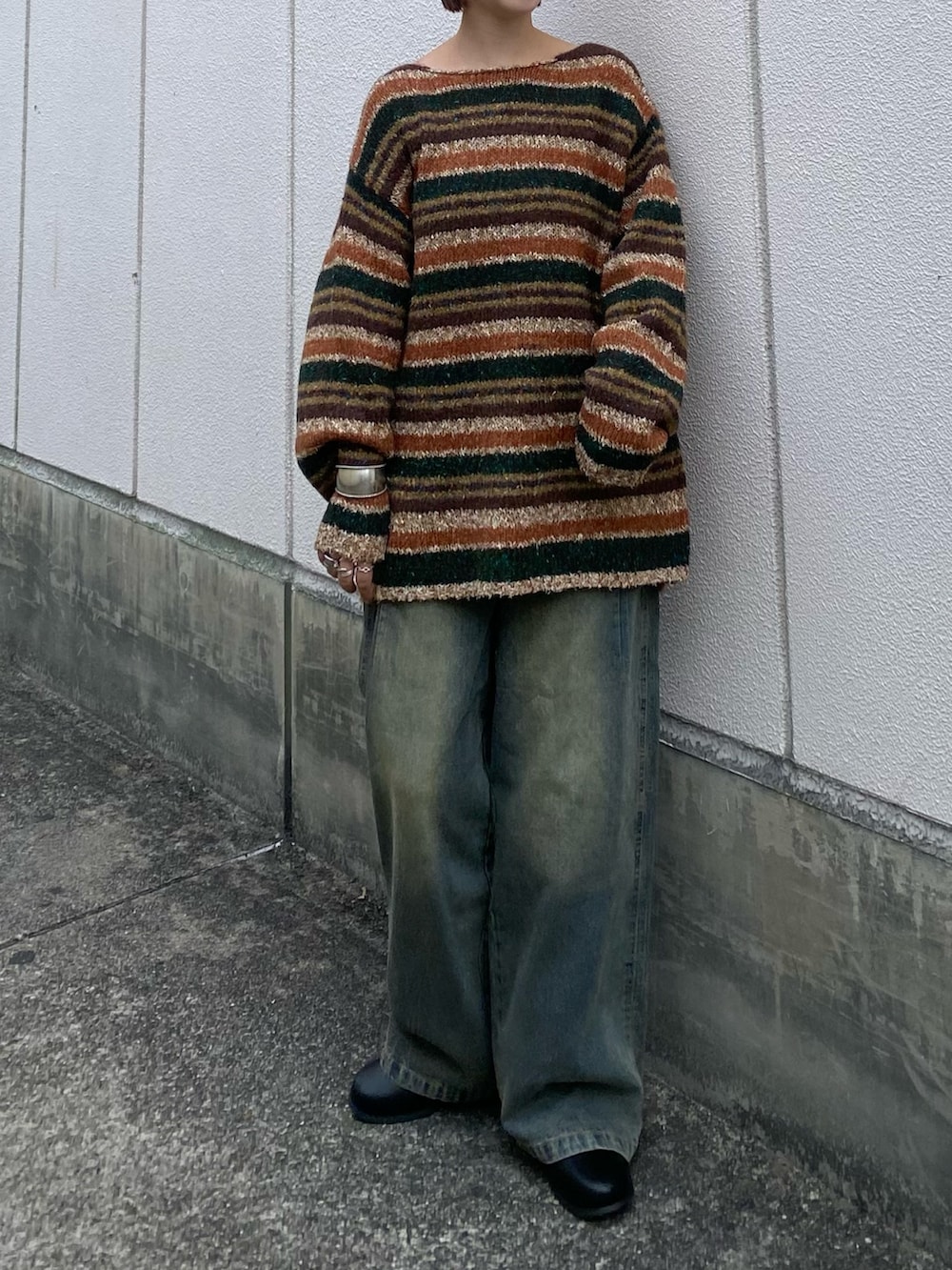 ブラウン系のニット/セーター、ブルー系のデニムパンツ、ブラック系のブーツを着用したレディースの冬コーディネートの2枚目の写真