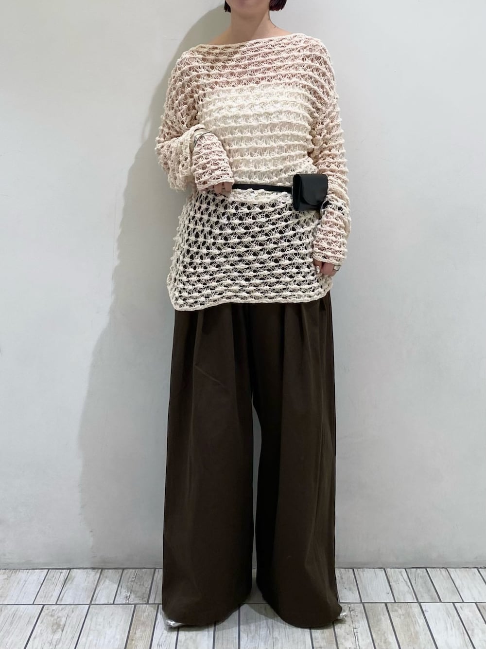 ホワイト系のニット/セーター、ブラウン系のその他パンツ、ブラック系のベルトを着用したレディースの春コーディネートの3枚目の写真