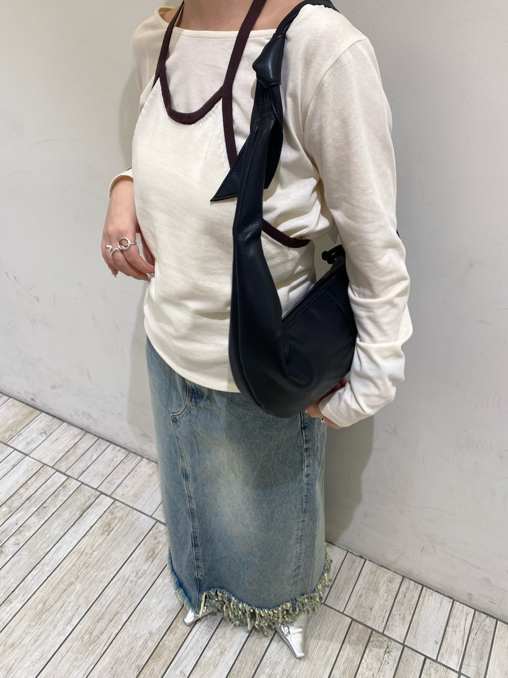 ホワイト系のTシャツ/カットソー、ブルー系のスカート、ブラック系のショルダーバッグを着用したレディースの春コーディネートの3枚目の写真