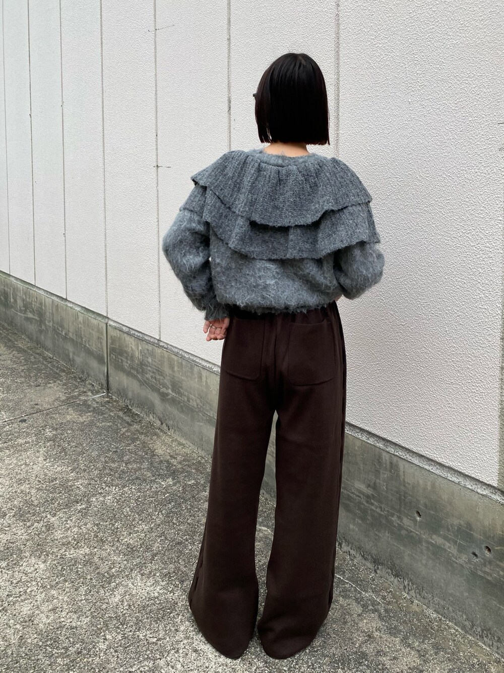 グレー系のニット/セーター、ブラウン系のその他パンツ、グレー系のその他シューズを着用したレディースの秋コーディネートの3枚目の写真