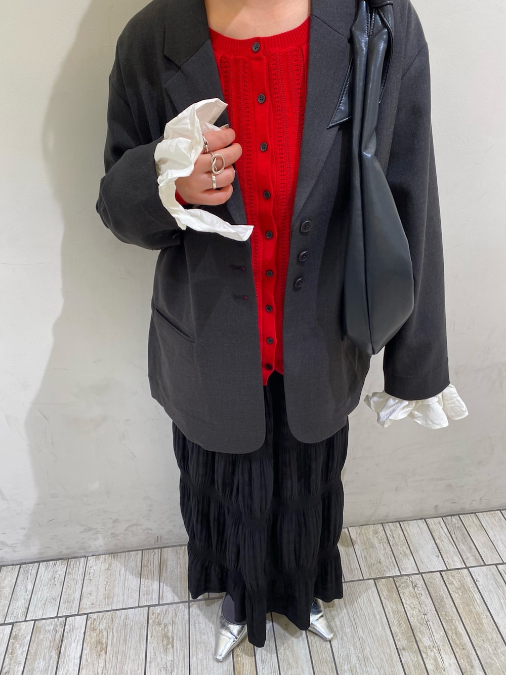 グレー系のその他アウター、レッド系のニット/セーター、ブラック系のセットアップを着用したレディースの春コーディネートの3枚目の写真