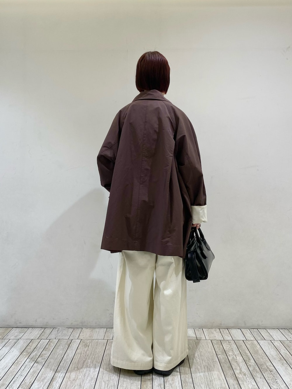 ブラック系のボストンバッグ、ホワイト系のTシャツ/カットソー、ブラウン系のその他アウターを着用したレディースの春コーディネートの2枚目の写真