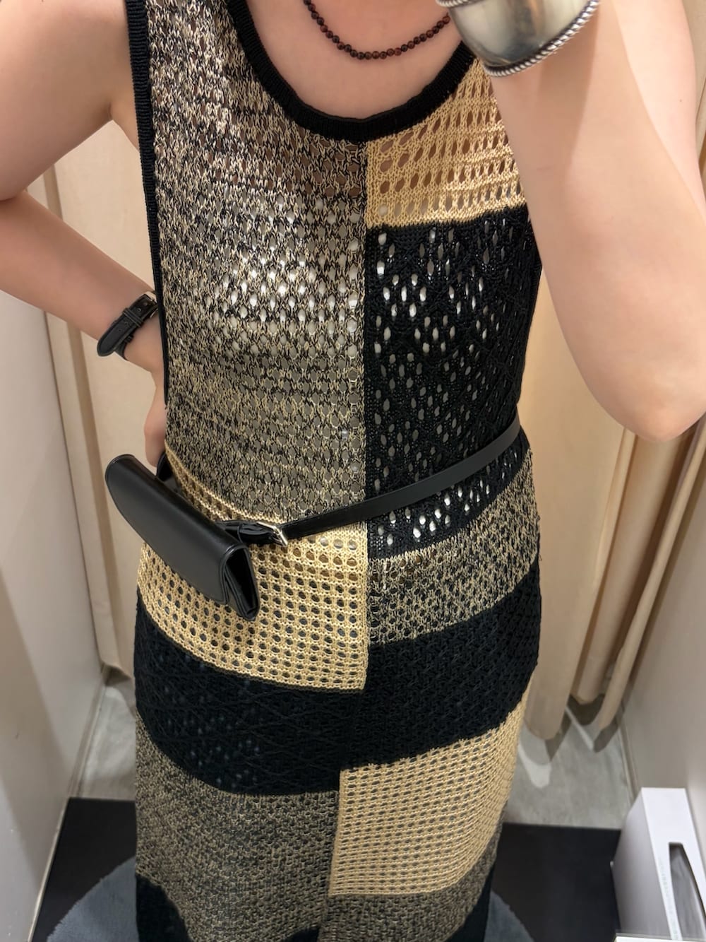 ベージュ系のワンピース、ブルー系のデニムパンツ、ブラウン系のネックレスを着用したレディースの夏コーディネートの3枚目の写真