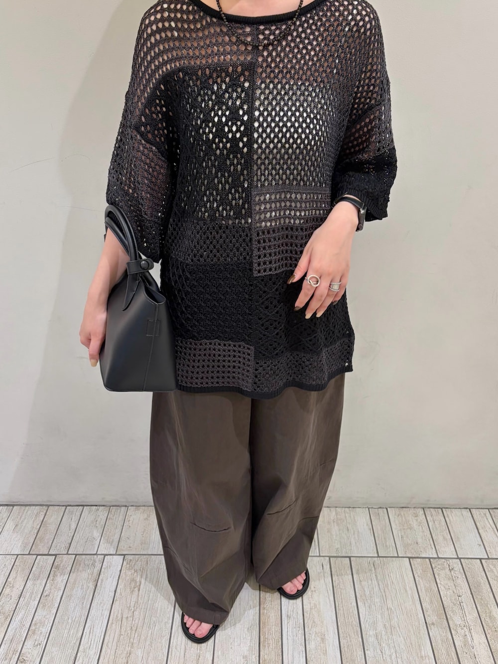 グレー系のその他パンツ、ブラック系のハンドバッグ、グレー系のニット/セーターを着用したレディースの夏コーディネートの4枚目の写真