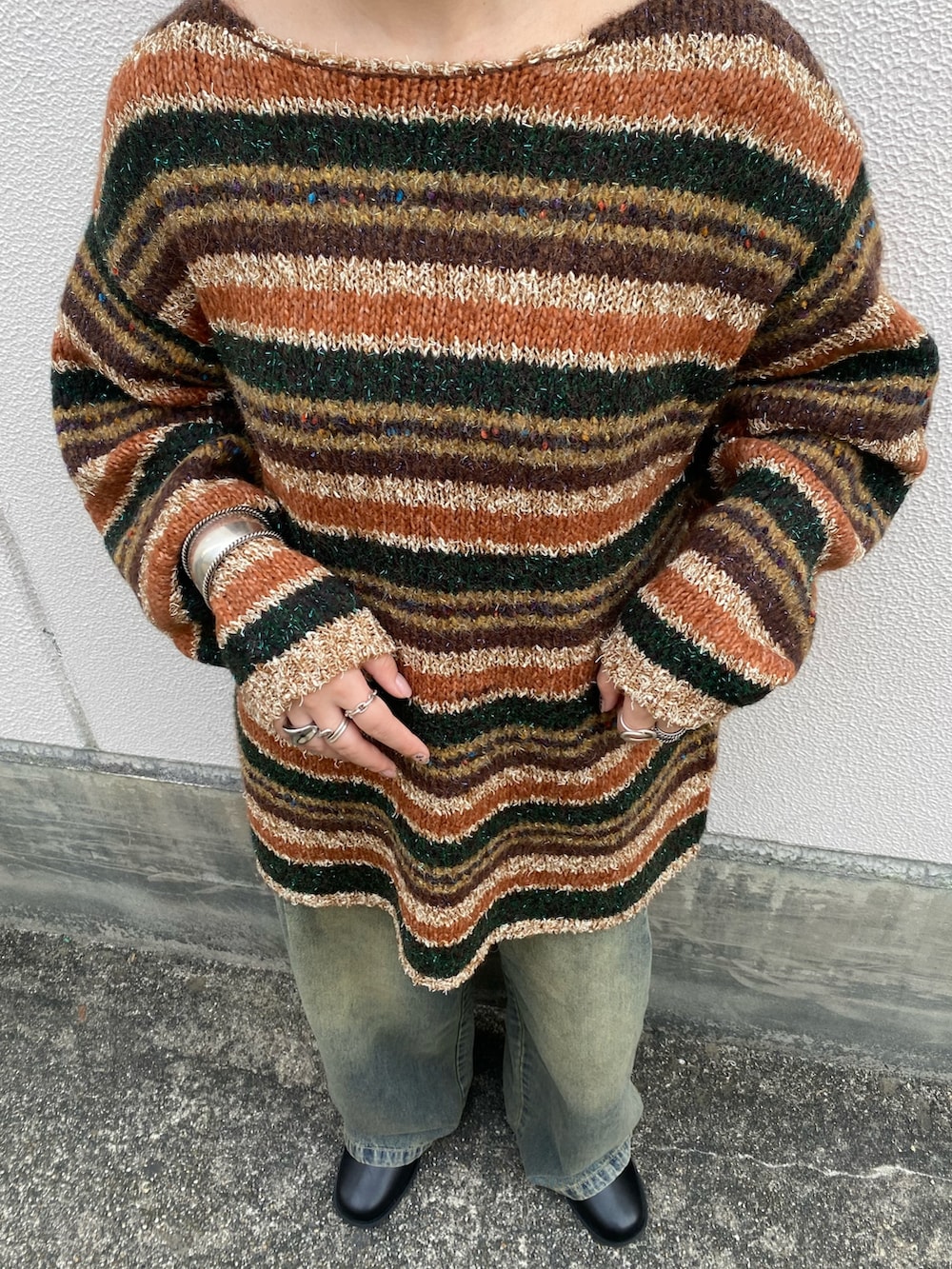 ブラウン系のニット/セーター、ブルー系のデニムパンツ、ブラック系のブーツを着用したレディースの冬コーディネートの5枚目の写真