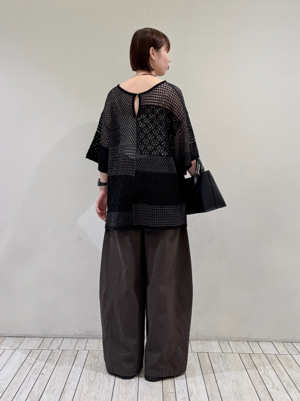 グレー系のその他パンツ、ブラック系のハンドバッグ、グレー系のニット/セーターを着用したレディースの夏コーディネートの3枚目の写真