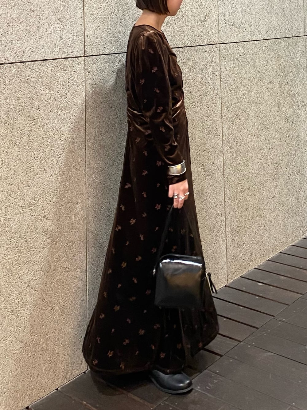 ブラウン系のワンピース、ブラック系のショルダーバッグ、ブラック系のブーツを着用したレディースの冬コーディネートの5枚目の写真