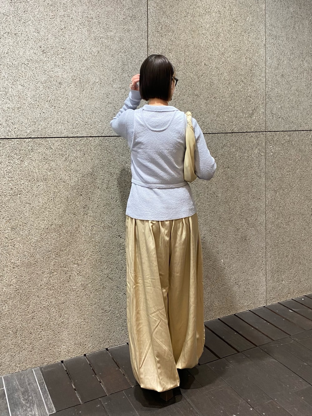 ベージュ系のその他パンツ、ホワイト系のハンドバッグ、ブルー系のニット/セーターを着用したレディースの冬コーディネートの4枚目の写真