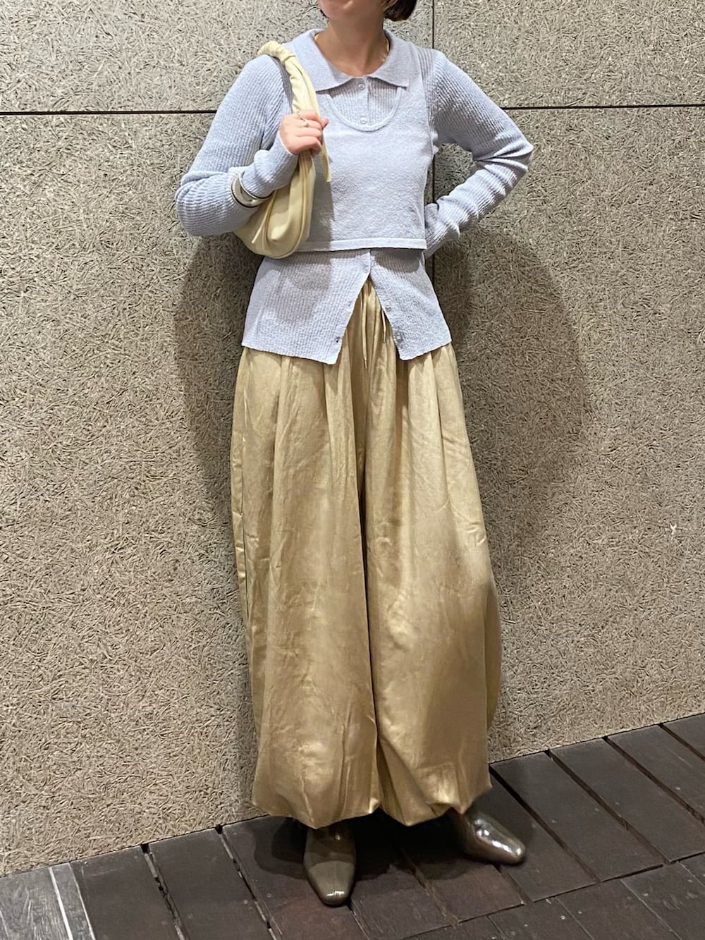 ベージュ系のその他パンツ、ホワイト系のハンドバッグ、ブルー系のニット/セーターを着用したレディースの冬コーディネートの2枚目の写真