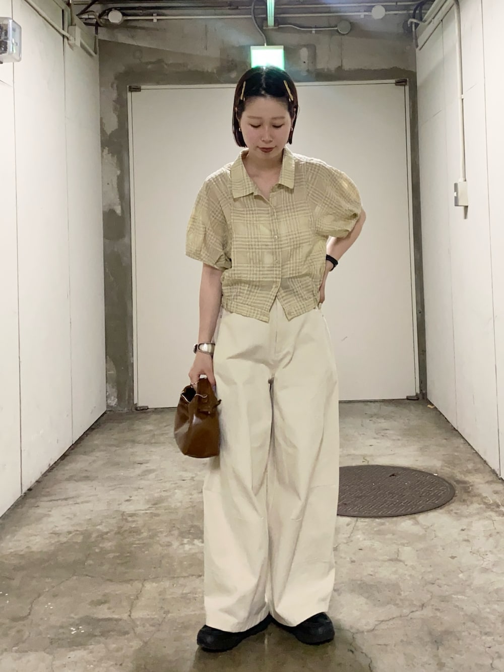イエロー系のシャツ/ブラウス、ホワイト系のその他パンツ、ブラウン系のハンドバッグを着用したレディースの夏コーディネートの2枚目の写真