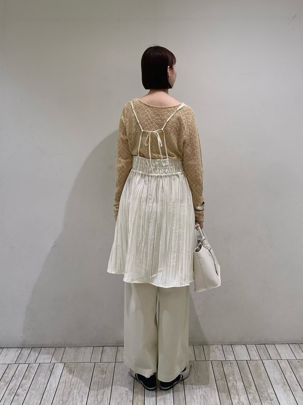 ホワイト系のワンピース、ホワイト系のその他パンツ、ベージュ系のTシャツ/カットソーを着用したレディースの春コーディネートの3枚目の写真